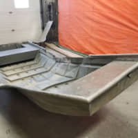 A damaged aluminum boat, recovered from the shores of the Nelson River by Royal Canadian Mounted Police (RCMP) searching for fugitive murder suspects Kam McLeod and Bryer Schmegelsky, is seen in Sundance, Manitoba, Sunday. | MANITOBA RCMP / HANDOUT / VIA REUTERS