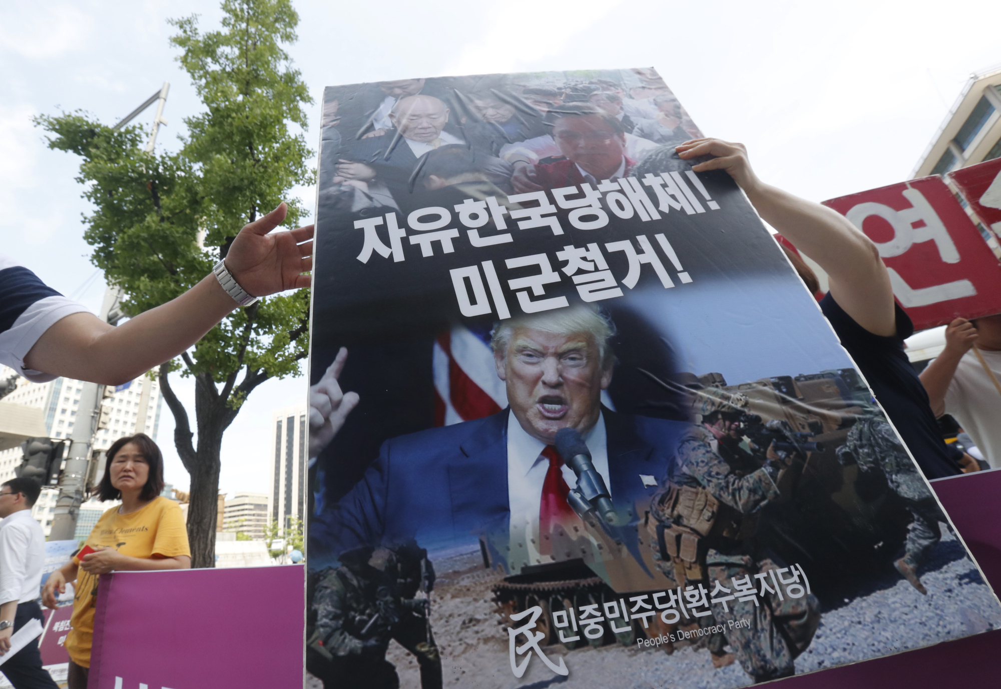 A protester carries a signboard during a rally near the U.S. Embassy in Seoul to oppose joint military exercises between South Korea and the United States on Tuesday. | AP