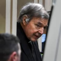 Australian Cardinal George Pell is escorted in handcuffs from the Supreme Court of Victoria in Melbourne on Wednesday. | AFP-JIJI