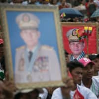 People hold portraits of Myanmar\'s military chief Min Aung Hlaing during a protest against the U.S., which banned him and three other officers from travel to the country, in Yangon on Saturday. | AFP-JIJI