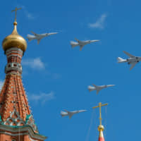 Russian army Tupolev Tu-160 (right) and Tupolev Tu-22M3 fly in formation over St. Basil\'s Cathedral during the rehearsal for the Victory Day parade in Moscow in May. | REUTERS