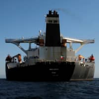 An Iranian flag flies at the stern of the Iranian oil tanker Adrian Darya 1, before being named as Grace 1, as it sits anchored after the Supreme Court of the British territory of Gibraltar lifted its detention order, in the Strait of Gibraltar, Spain, Sunday. | REUTERS