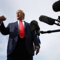 President Donald Trump speaks with reporters before boarding Air Force One at Morristown Municipal Airport in Morristown, New Jersey, Thursda en route to a campaign rally in Manchester, New Hampshire. | AP