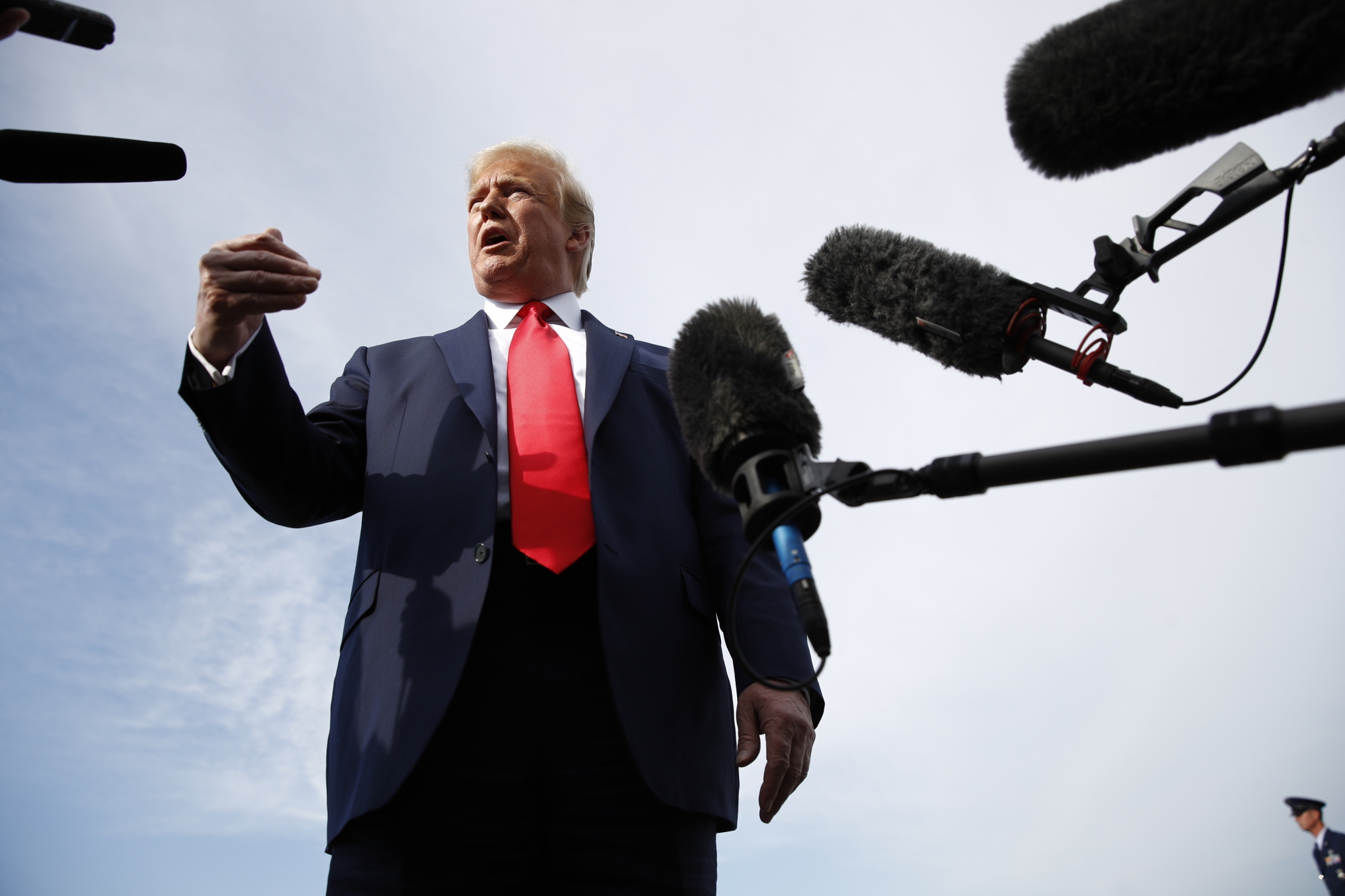 President Donald Trump speaks with reporters before boarding Air Force One at Morristown Municipal Airport in Morristown, New Jersey, Thursda en route to a campaign rally in Manchester, New Hampshire. | AP