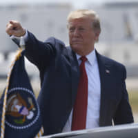 President Donald Trump points to the crowd after arriving on Air Force One at Louisville International Airport in Louisville, Kentucky, Wednesday. | AP