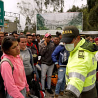 Venezuelans gather to cross into Ecuador from Colombia, most of them trying to reach Peru as one of the most welcoming destinations for migrants in South America, in Tulcan, Ecuador, in June. | REUTERS