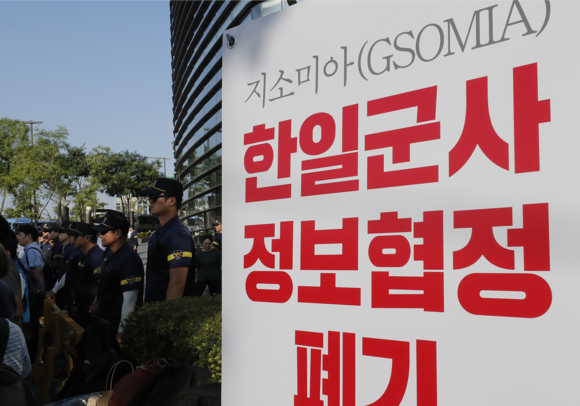 South Korean police officers stand next to a banner during a rally demanding the South Korean government to abolish the General Security of Military Information Agreement (GSOMIA), an intelligence-sharing agreement between South Korea and Japan, in front of Japanese embassy in Seoul, on Thursday. | AP