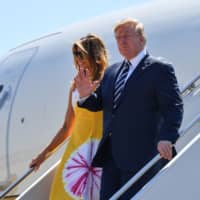 U.S. President Donald Trump waves flanked by his wife, Melania Trump, as they disembark from an airplane upon landing at the Biarritz Pays Basque Airport in Biarritz, southwest France, on Saturday on the first day of the annual G7 Summit. | AFP-JIJI