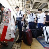 Passengers heading off on their summer vacations board a shinkansen train at Tokyo Station on Saturday. | KYODO