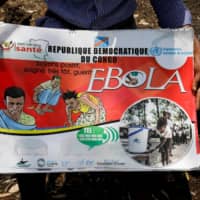 A Congolese volunteer displays a flip book he uses to inform people about the Ebola virus, in Goma, Congo, on Saturday. A woman in her 70s from Saitama Prefecture who recently returned from a visit to Congo has tested negative for a possible Ebola infection at a medical institute in Tokyo, the health ministry said Sunday. | REUTERS