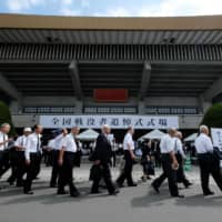 People arrive for a memorial ceremony for the war dead at Nippon Budokan Hall, adjoining the Imperial Palace in Tokyo, on Thursday as Japan marks the 74th anniversary of its surrender in World War II. | AFP-JIJI