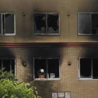 An investigator takes pictures inside the Kyoto Animation studio destroyed in an arson attack, on July 19. | AP