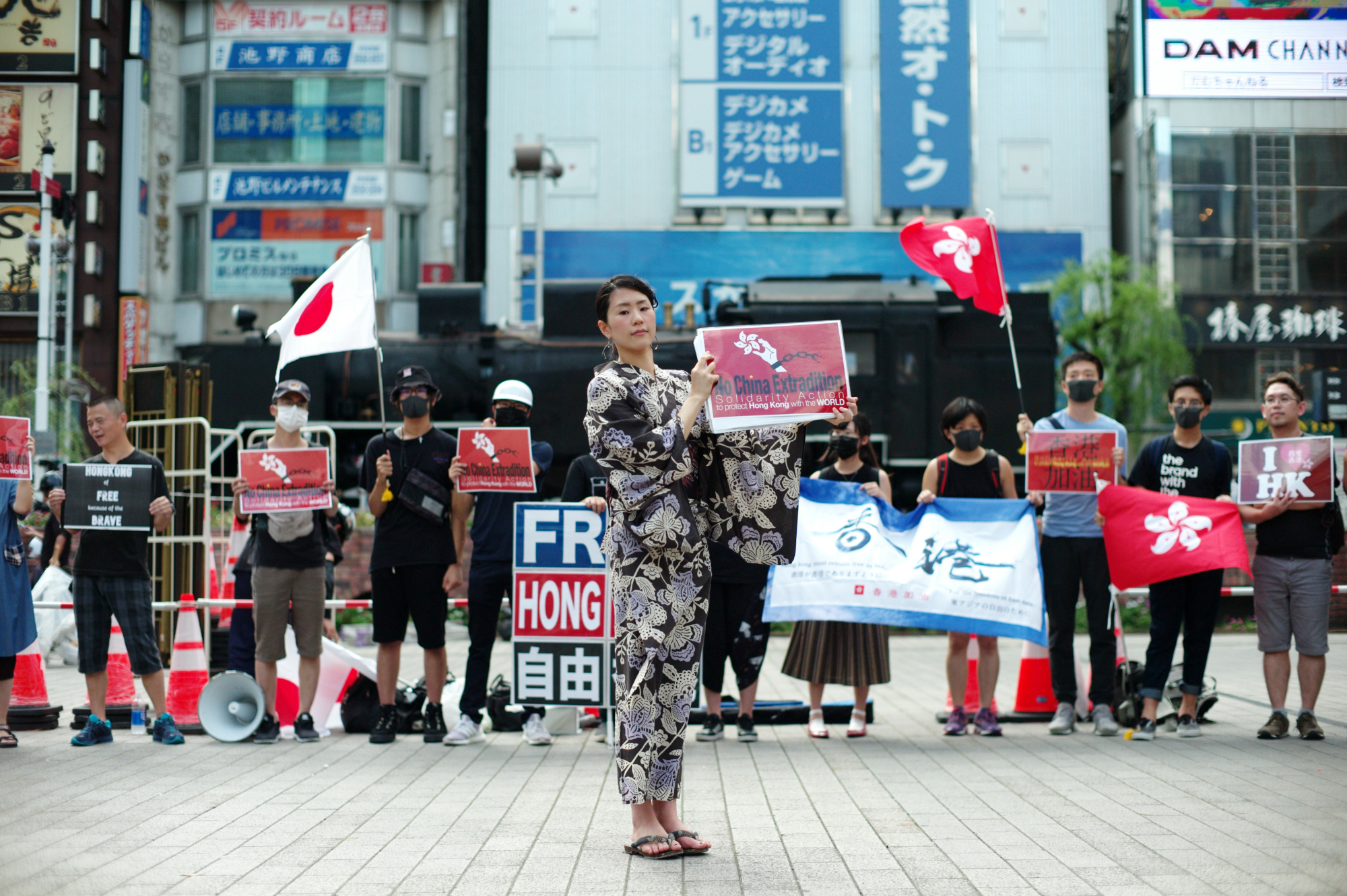 Suzuko Hirano, 25, stands in front of protesters at a demonstration she organized at Tokyo's Shinbashi Station in July to support protesters in Hong Kong fighting a bill that would allow Hong Kongers to be extradited to mainland China. | RYUSEI TAKAHASHI