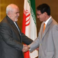 Iranian Foreign Minister Mohammad Javad Zarif shakes hands with Foreign Minister Taro Kono during their meeting at a hotel in Yokohama on Tuesday.  | POOL / VIA AFP-JIJI