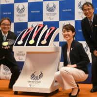 Sakiko Matsumoto (center), who designed the medals for next year\'s Tokyo Paralympics, poses for a photo during the one-year countdown event in Tokyo on Sunday. | YOSHIAKI MIURA