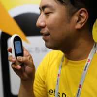 A Pocketalk mobile language translation unit is demonstrated at the Sourcenext Corp. stand during a trade fair in Barcelona, Spain, in February. | BLOOMBERG