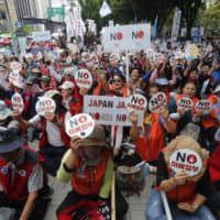 Protesters stage a rally to denounce Japan\'s trade restrictions on South Korea in Seoul on Tuesday. | AP