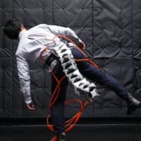 A man wears the Arque, a 1-meter mechanical tail that helps people keep their balance while running and climbing. | COURTESY OF KEIO UNIVERSITY GRADUATE SCHOOL OF MEDIA DESIGN