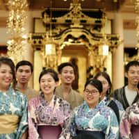 Foreign students wearing kimono pose for a photo at Komyoji temple in Arakawa Ward, Tokyo, on Thursday. | RYUSEI TAKAHASHI