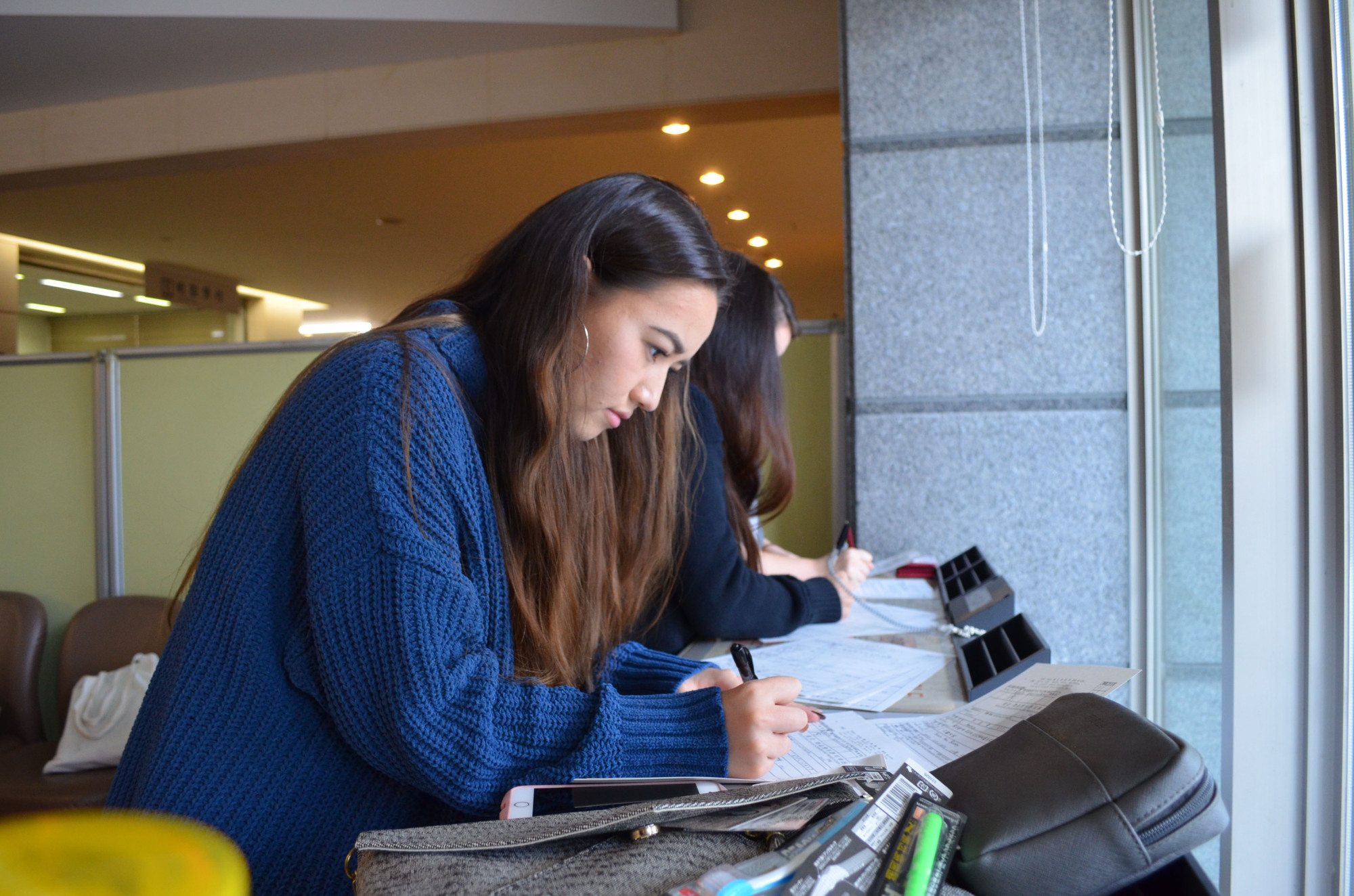 Necessary prep: A student from Sophia University fills out paperwork ahead of a detention center visit. | REI ANDO