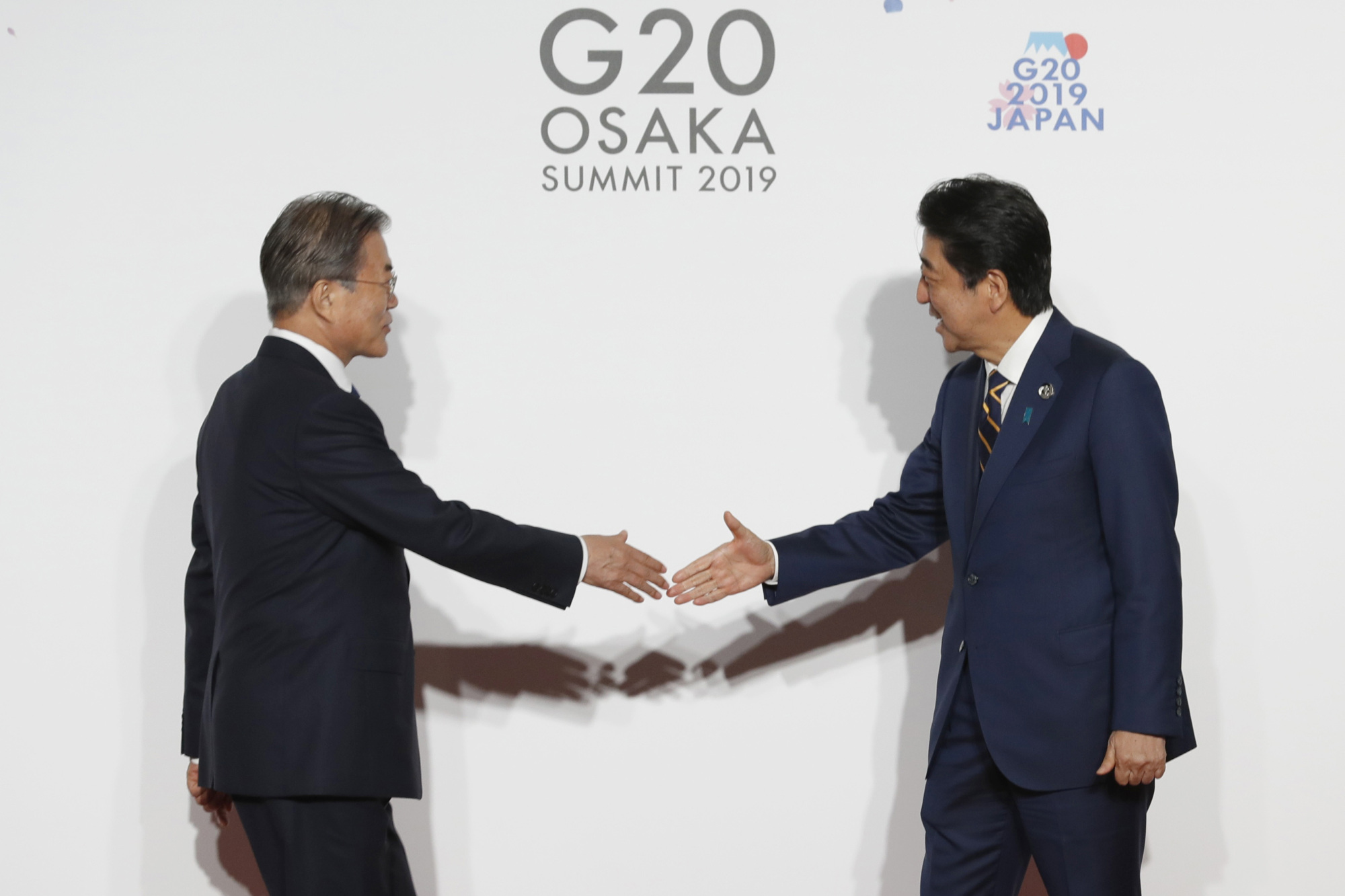 Prime Minister Shinzo Abe greets South Korean President Moon Jae-in in Osaka on June 28. The Abe government has a solid record of trying to foster better ties with South Korea. | BLOOMBERG
