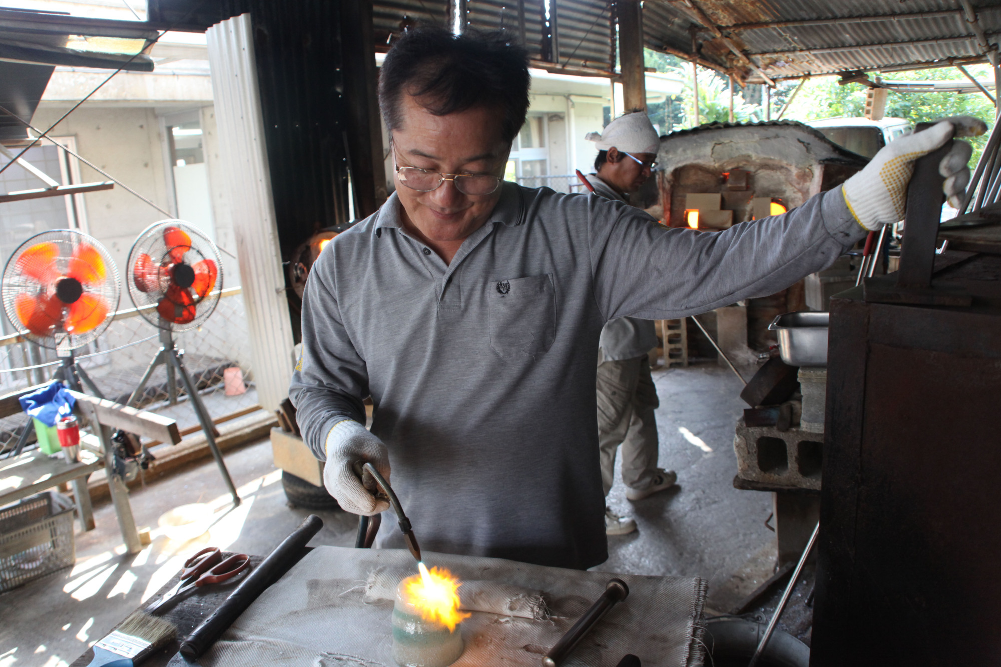 A master technician: Kiyoharu Matsuda levels off the bottom of a glass in his studio. | KENGO TARUMI