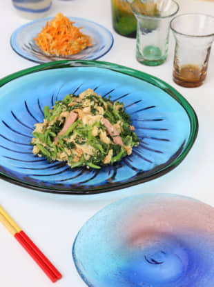 Glass with class: Tabletop rhapsody in blues. Matsuda's wife, Misao, arranged these Okinawan dishes — fu-chanpurū (wheat gluten stir-fried with tofu) in front and ninjin shirishiri (sliced carrots with egg and tuna) in back. | KENGO TARUMI