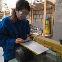 It\'s in the layers: Shiori Aiba cuts a block of layered colored paper, a textile that she designs and uses for her line of jewelry. | KARIN SHIKATA