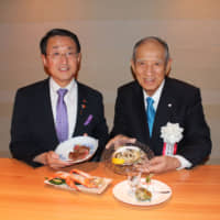 Tottori Gov. Shinji Hirai (left) and Fujiya Co. Chairman Kensuke Yamada introduce some samples of the delectable dishes at Tottori Wagyu Daisen Fujiya Shinsaibashi Honten in Osaka on July 6. | MASAAKI KAMEDA