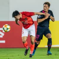 Guangzhou Evergrande\'s Deng Hanwen (left) vies for the ball with Kei Koizumi of the Kashima Antlers in an Asian Champions League quarterfinal first-leg match in Guangzhou, China, on Wednesday. | AFP-JIJI