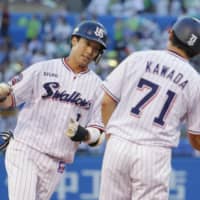 The Swallows\' Tetsuto Yamada is congratulated by third base coach Yusuke Kawada after his two-run home run against the BayStars on Wednesday at Jingu Stadium. | KYODO