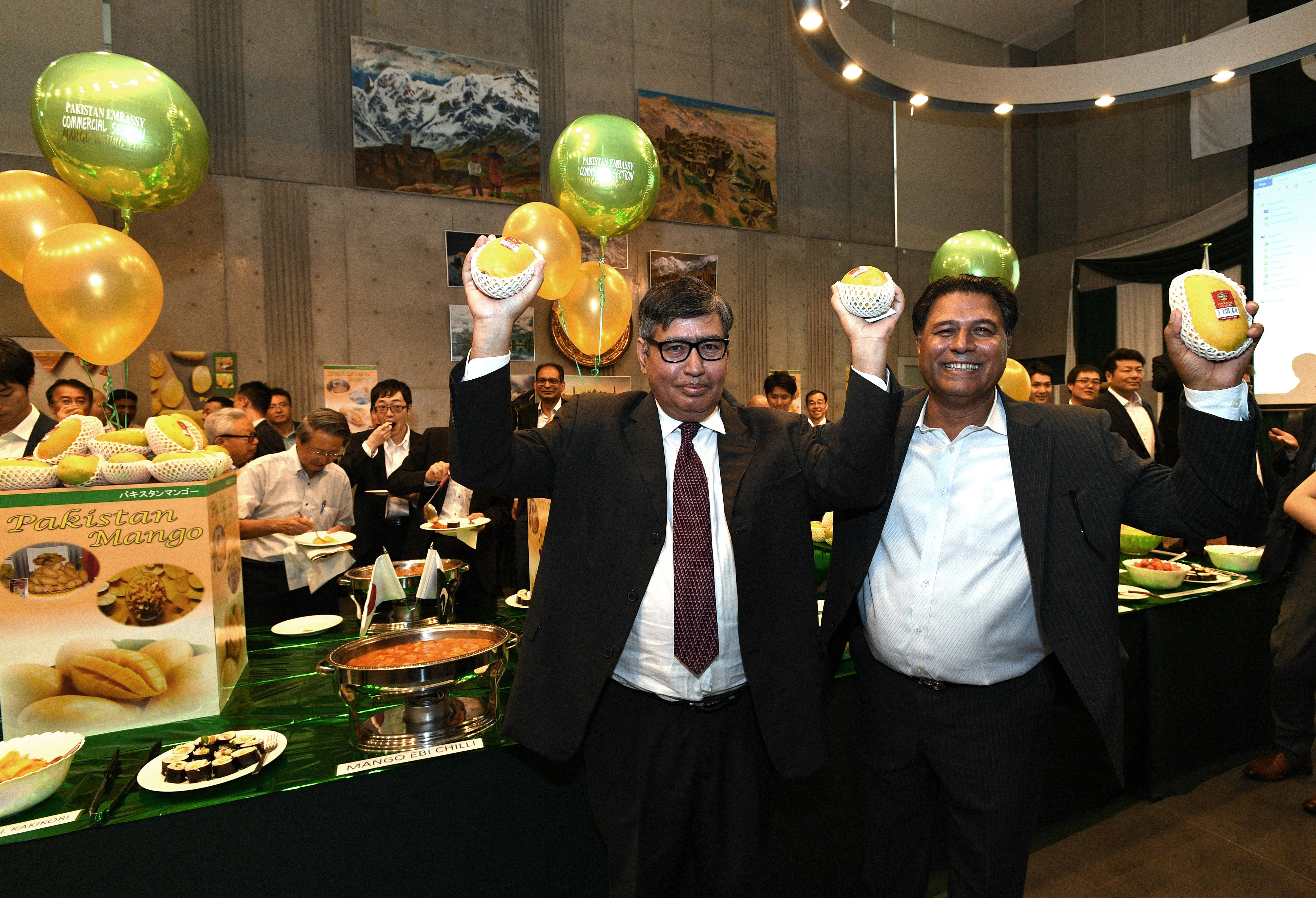 Pakistan Ambassador-designate Imtiaz Ahmad (left) and Mian Ramzan Siddique, managing director of Washin Trading Co., hold up mangos from Pakistan during the Pakistan Mango Festival at the embassy on      Aug. 7. yoshiaki miura | 
