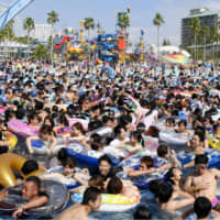 Nagashima Spa Land\'s pool in Kuwana, Mie Prefecture, is crowded with swimmers and flotation devices on Sunday. About 40,000 people visited the amusement park on the last Sunday of the month as the mercury touched 33.2 degrees. | KYODO