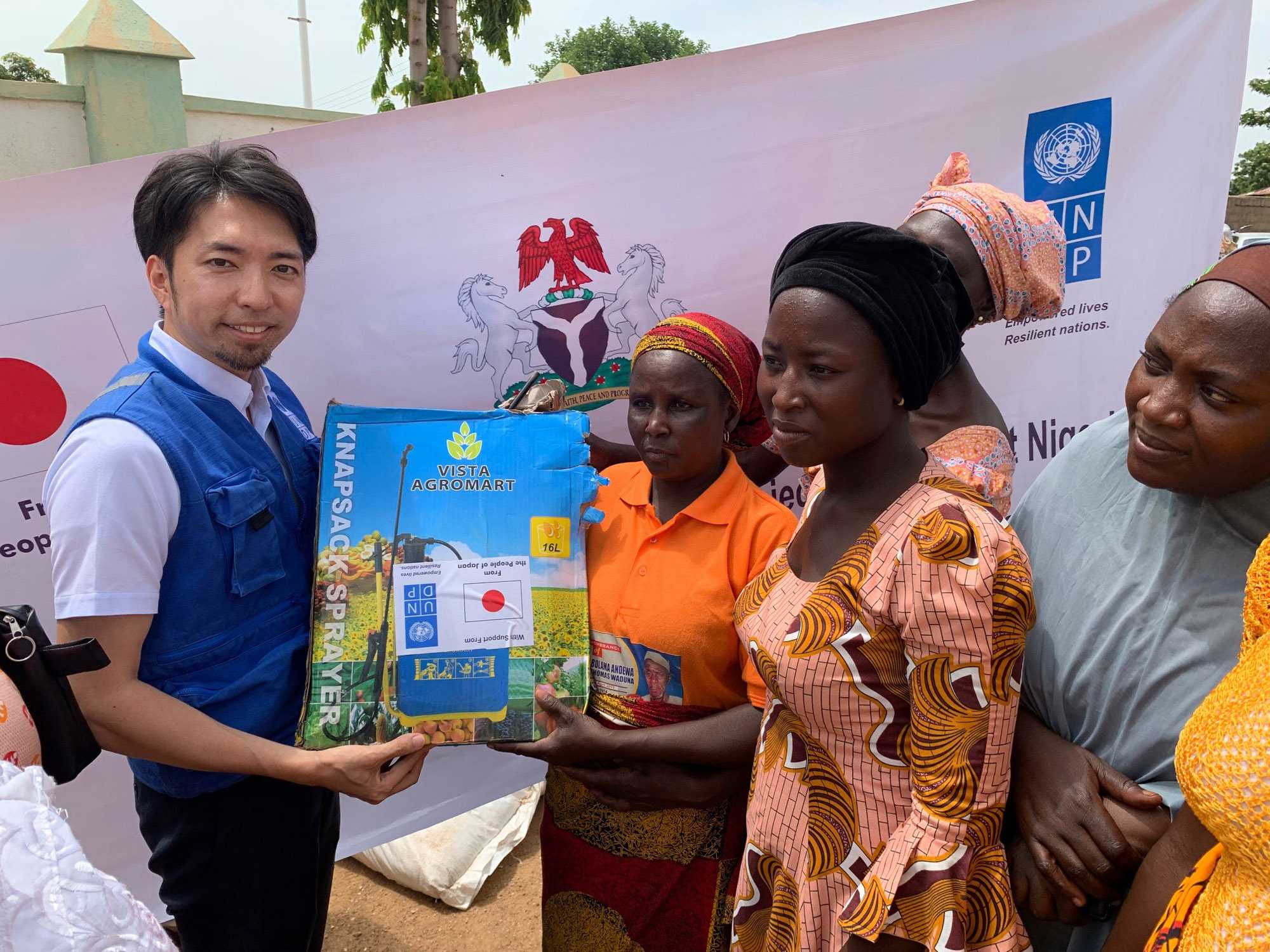 A UNDP staffer provides agricultural tools, fertilizer and seeds to community members in Michika, Yobe state, Nigeria. | UNITED NATIONS DEVELOPMENT PROGRAMME