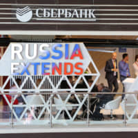 A Sberbank of Russia PJSC logo sits displayed above a corporate stand during the opening day of the Eastern Economic Forum in Vladivostok, Russia, on Wednesday. | BLOOMBERG