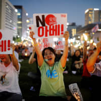 South Korean people chant slogans during an anti-Japan rally in Seoul on Aug. 24. | REUTERS