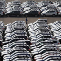 New cars await transport at a shipping terminal in Yokohama. | REUTERS