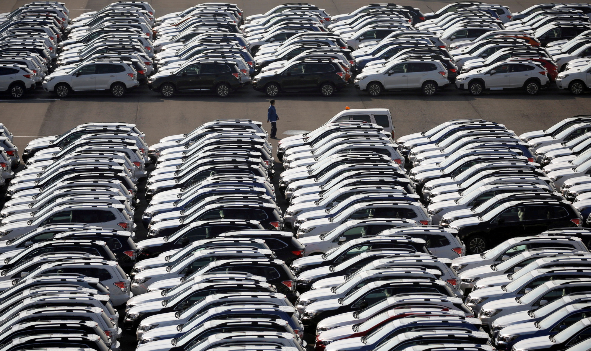 New cars await transport at a shipping terminal in Yokohama. | REUTERS