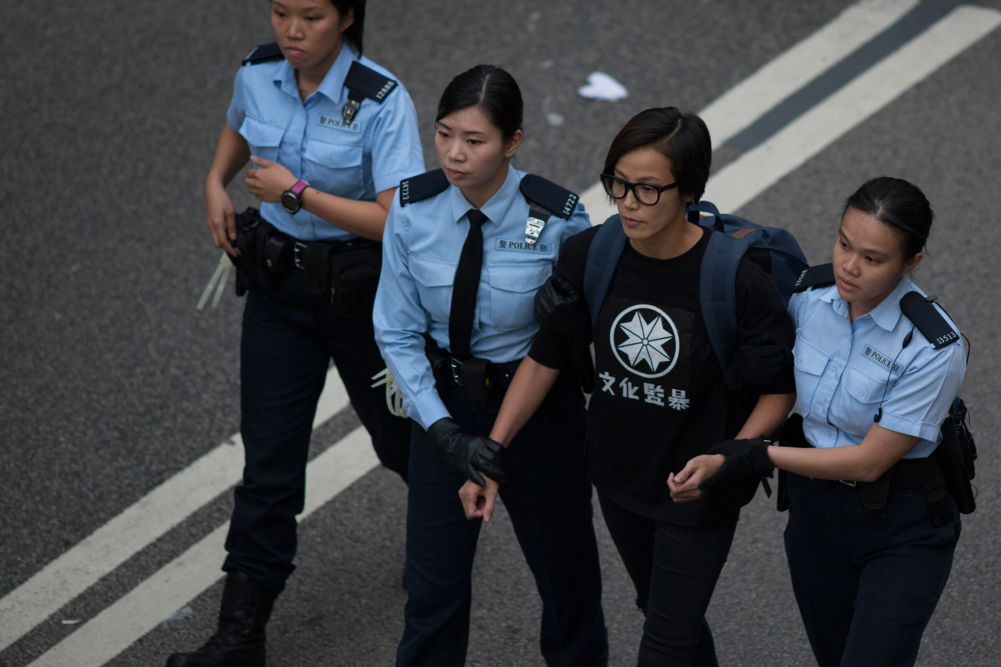 Denise Ho, singer and activist, is arrested by police in Hong Kong in December 2014. Ho said Beijing is using its power and influence to quash dissent around the world, and urged businesses who invest in China and Hong Kong to support human rights and democracy. | BLOOMBERG