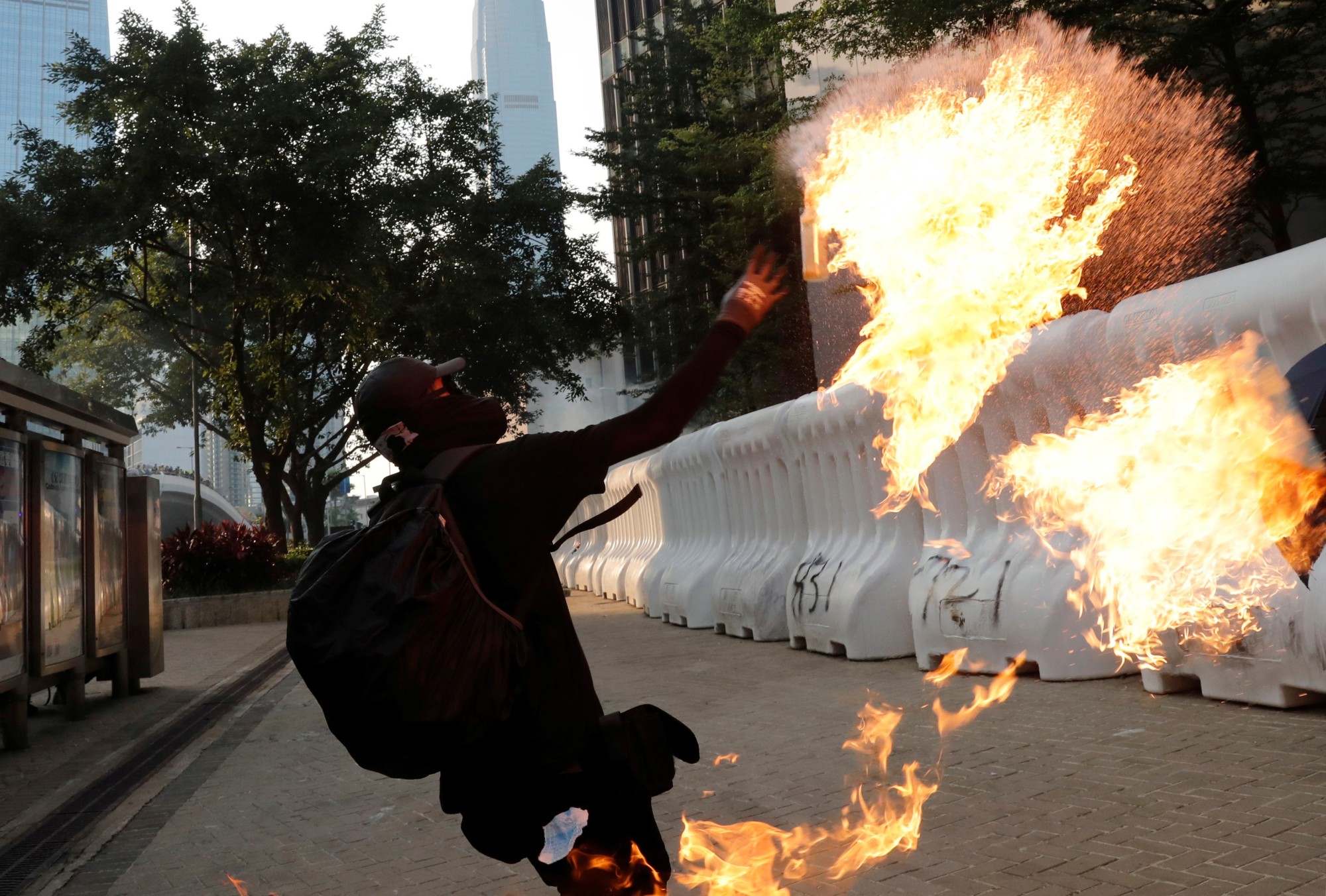 An anti-government protester throws a petrol bomb during a demonstration near the Central Government Complex in Hong Kong on Sunday. | REUTERS