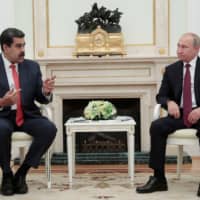 Russian President Vladimir Putin (right) and Venezuelan President Nicolas Maduro attend a meeting at the Kremlin in Moscow Wednesday. | SERGEI CHIRIKOV / POOL / VIA REUTERS