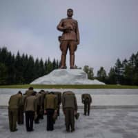 People pay their respects before a statue of late North Korean leader Kim Il Sung in North Korea\'s northern city of Samjiyon Sept. 13. | AFP-JIJI