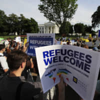 Refugees and community activists gather in front of the White House in Washington in 2017. The Trump administration wants to cap the number of refugees admitted into the United States to the lowest number since the resettlement program was created in 1980. A State Department proposal released Thursday would put a cap on the number of refugees at 18,000 for the fiscal year that starts Oct. 1. | AP