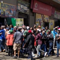 South African looters take items from an alleged foreign-owned shop during a riot in the Johannesburg suburb of Turffontein on Monday in a new wave of violence targeting foreign nationals. | AFP-JIJI