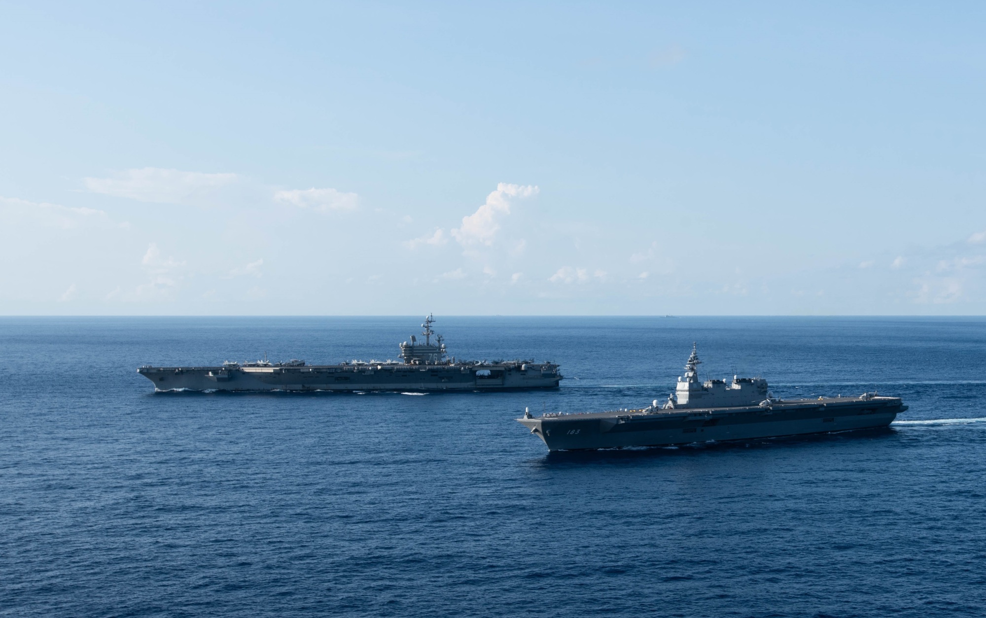 The USS Ronald Reagan sails alongside the Maritime Self-Defense Force's Izumo helicopter carrier (front) while conducting operations in the South China Sea on June 19. | U.S. NAVY