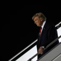 U.S. President Donald Trump disembarks from Air Force One at John F. Kennedy International Airport in New York on Sunday. | REUTERS