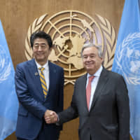 Prime Minister Shinzo Abe and United Nations Secretary-General Antonio Guterres shake hands during the U.N. General Assembly in New York on Tuesday. | AP