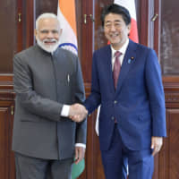 Prime Minister Shinzo Abe and his Indian counterpart Narendra Modi shake hands before talks in Vladivostok, Russia, on Thursday. | KYODO