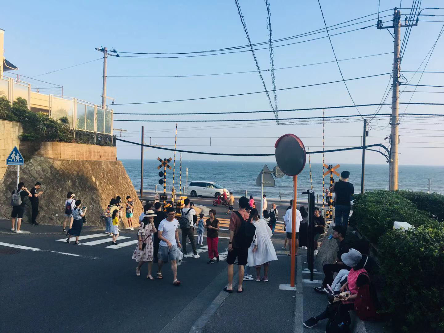Tourists take photos next to a railway crossing near Kamakura High School that appeared in the hit Japanese anime 'Slam Dunk.' | COURTESY OF GUAN HUIWEN
