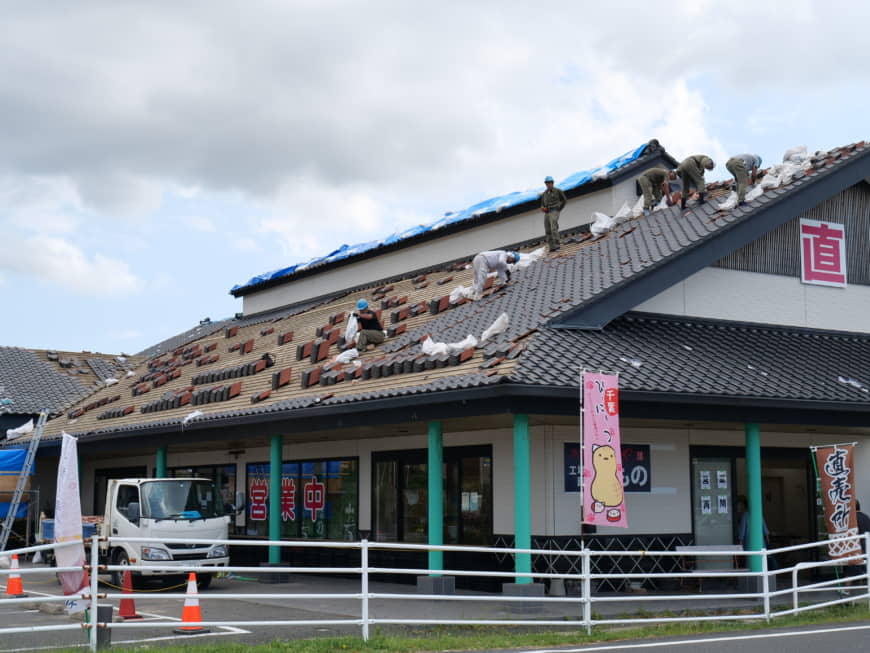 Repair workers fix roof tiles on a house in Minamiboso, Chiba Prefecture, on Sept. 25. The tiles were blown off by strong winds from Typhoon Faxai when the storm passed over the area earlier this month. | CHISATO TANAKA